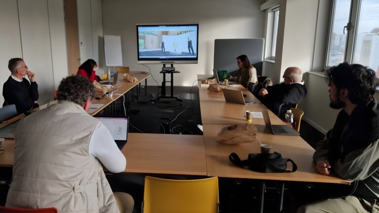 A team of professionals attends a plenary meeting in a modern conference room, watching a virtual showroom demo projected on a large screen.